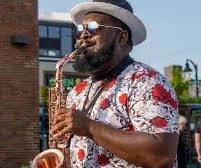 Man playing saxophone on a street corner in Greektown